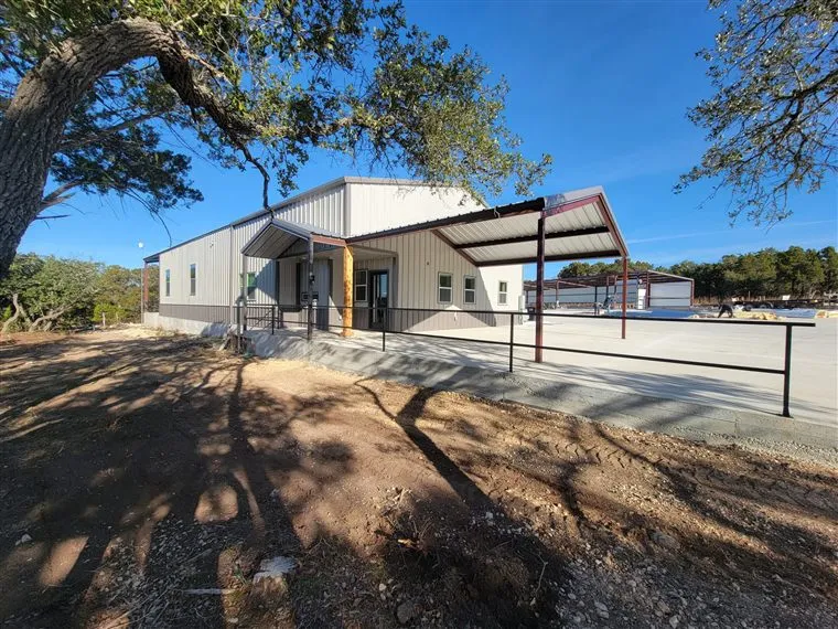 Finished white steel commercial building with a covered entry canopy and accessible ramp