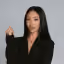 Photo of a woman with long dark hair wearing a black top on a white background.