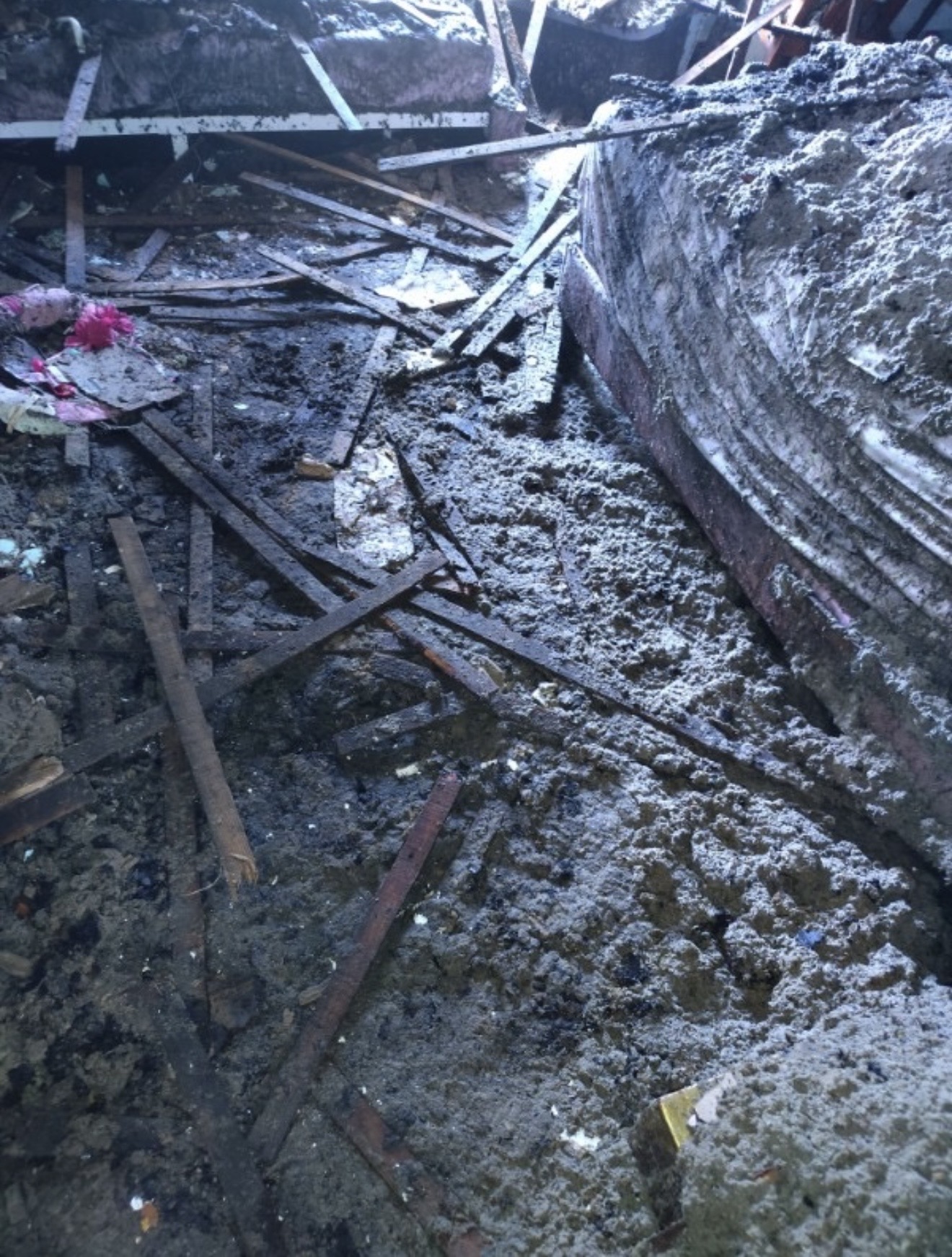 Fire-damaged room with collapsed debris and severe interior loss.