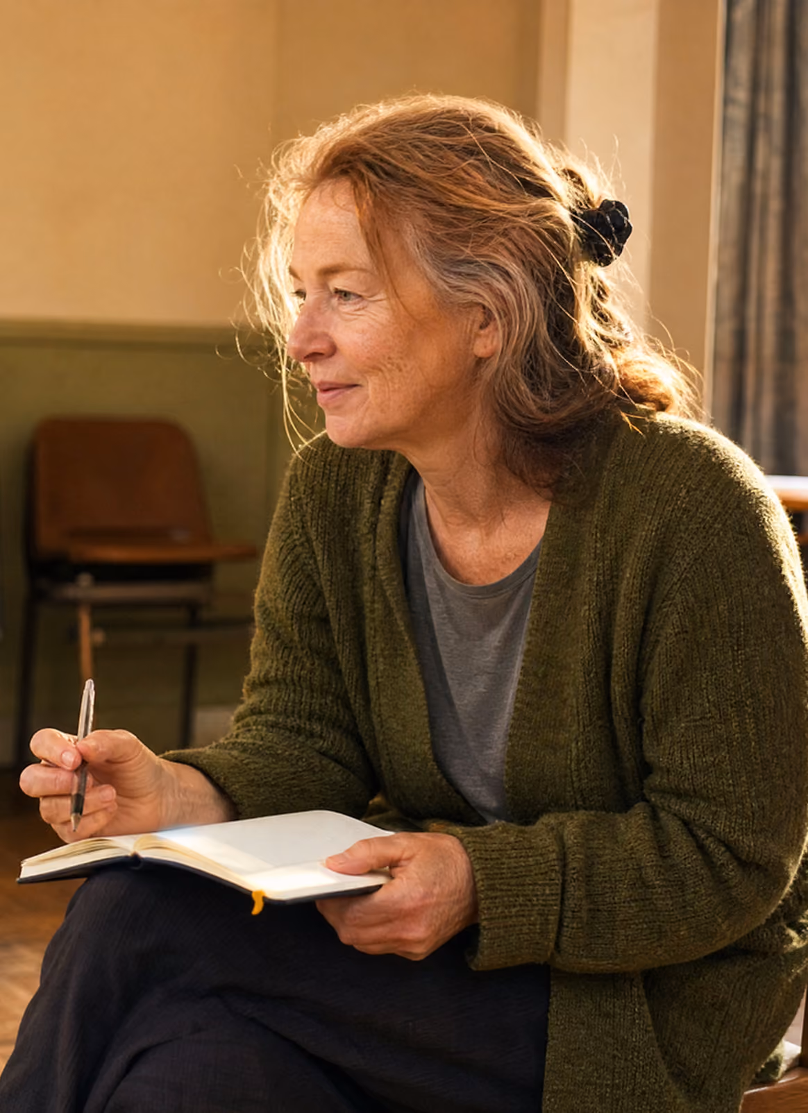 Therapeutic practitioner writing in a notebook during a reflective session
