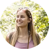 Smiling young woman outdoors among trees