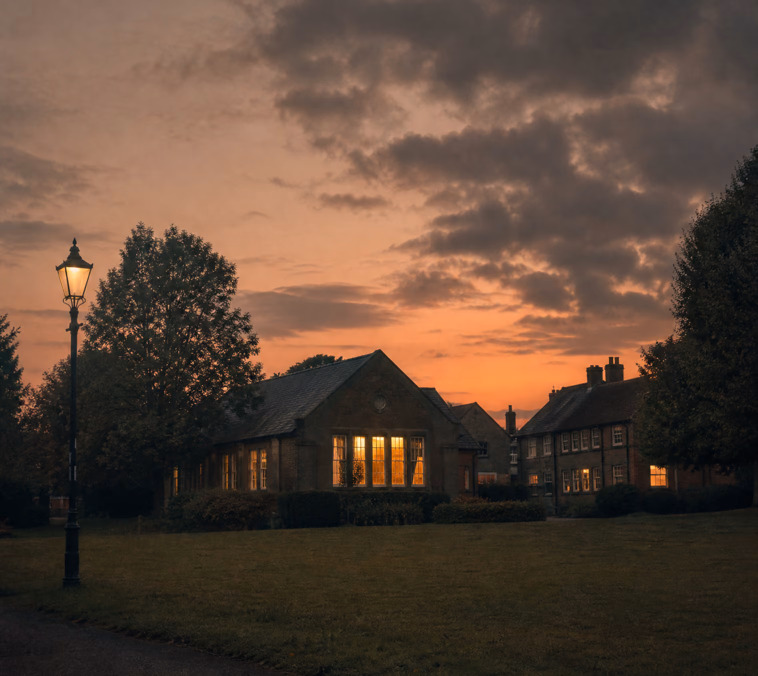 House with lit windows under a sunset sky
