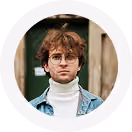 Young man with curly hair and glasses