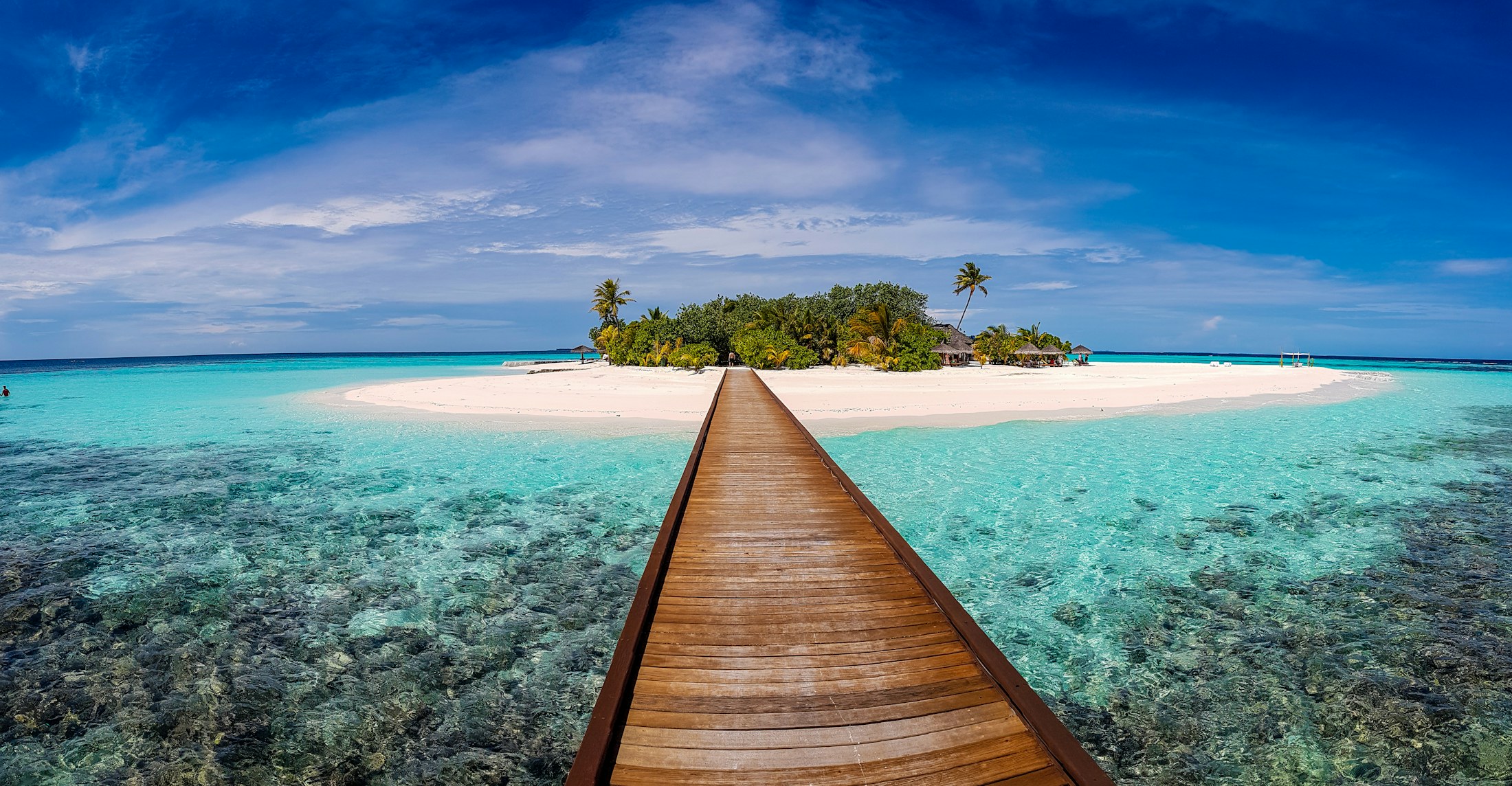 A wooden boardwalk over clear Caribbean water