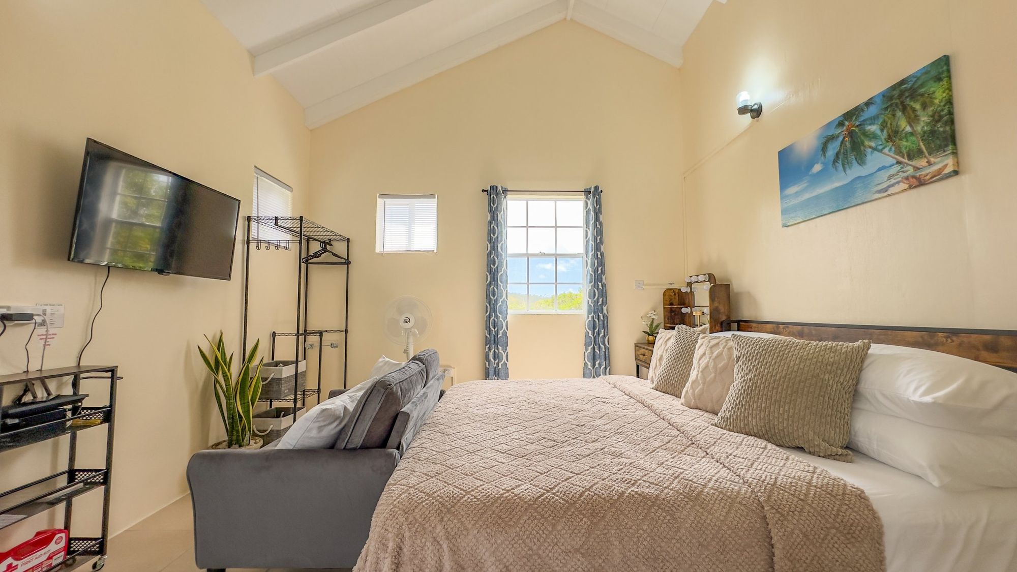 A bright suite bedroom with a vaulted ceiling