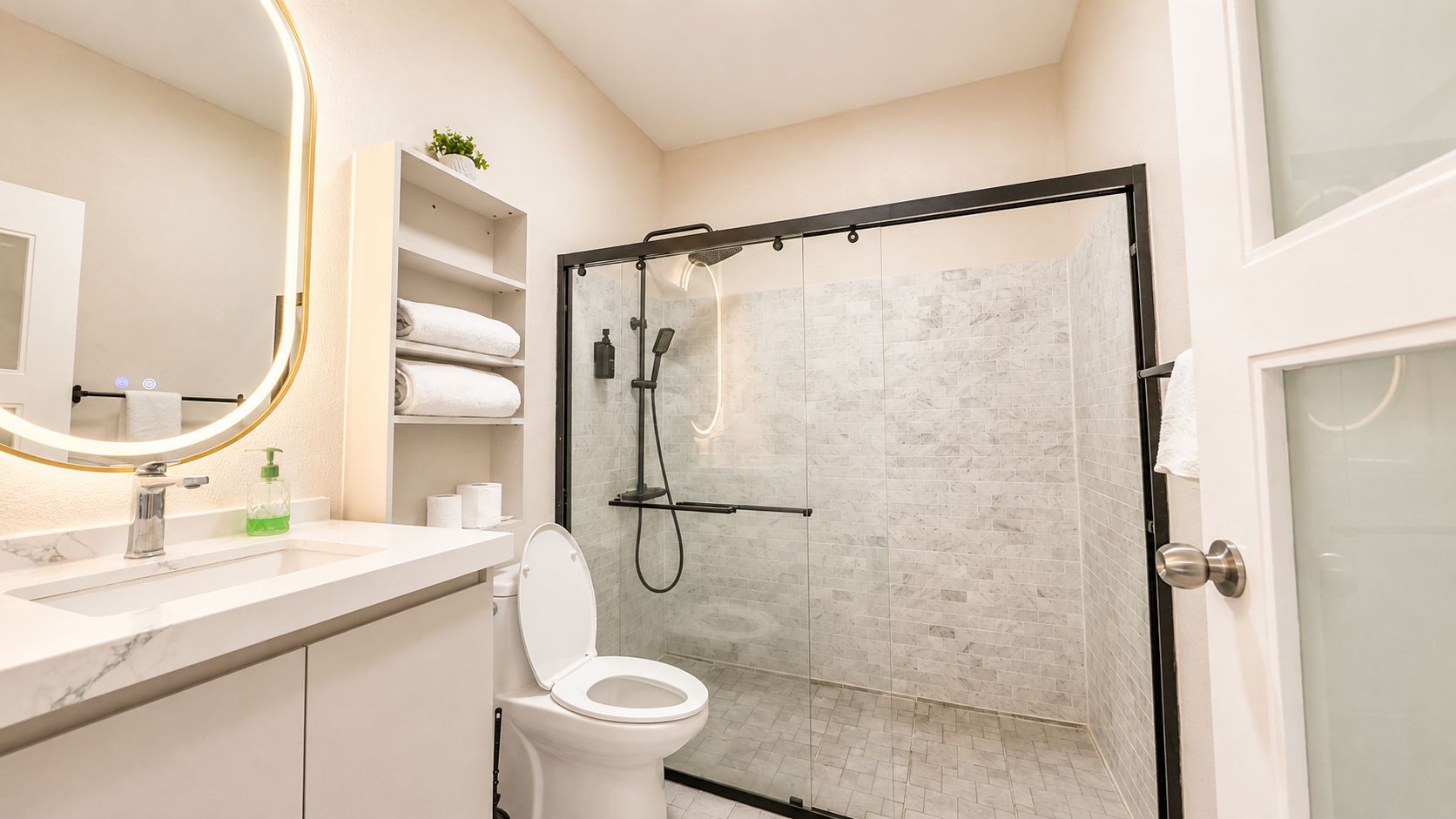 A marble-tiled walk-in shower and vanity