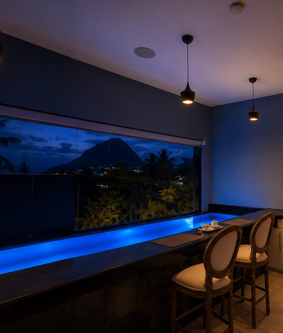 Blaize Inn's lit private pool and kitchen bar at dusk, with a view of the Piton