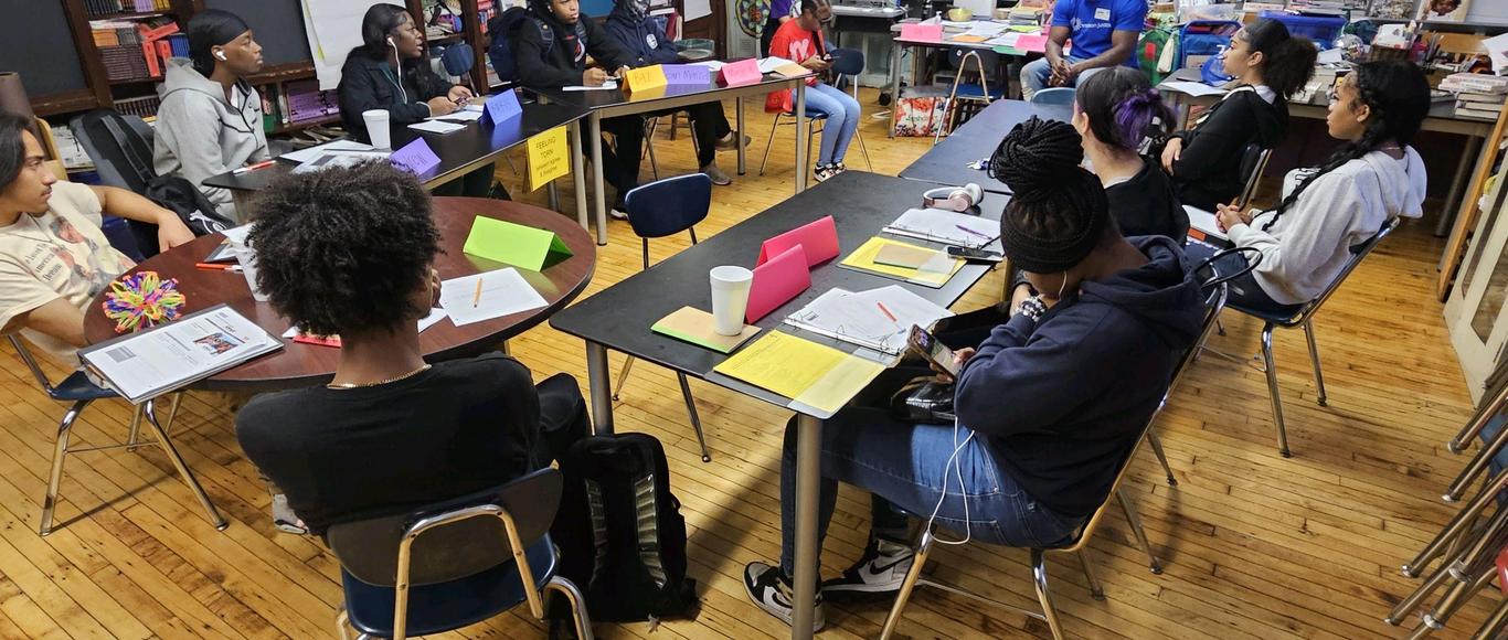 Students seated at tables in a collaborative classroom discussion
