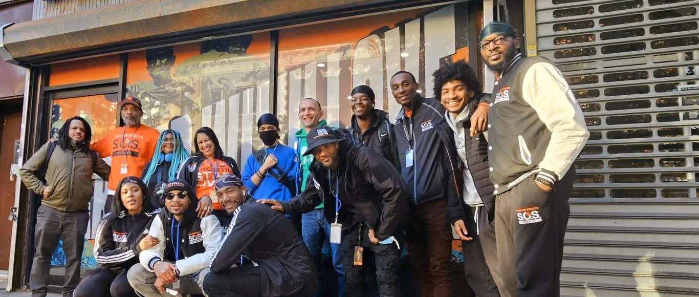 SOS program staff and students posing together outside storefront