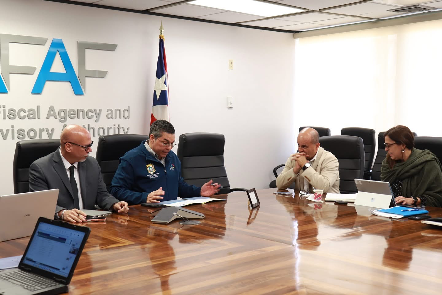 Eng. Josué A. Colón Ortiz discusses with transportation officials at government offices.