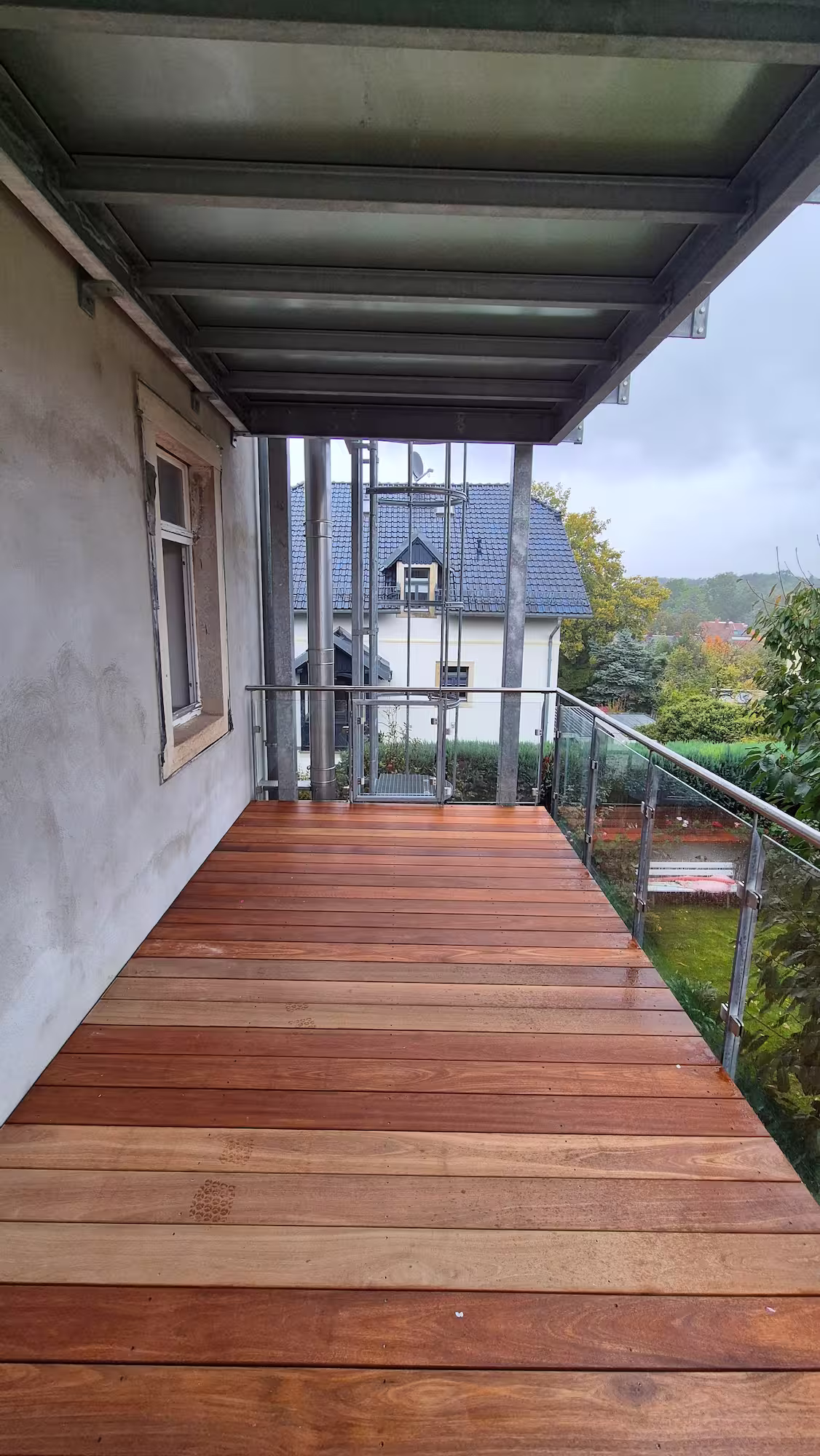 Überdachter Balkon mit fertig verlegtem Holzbelag