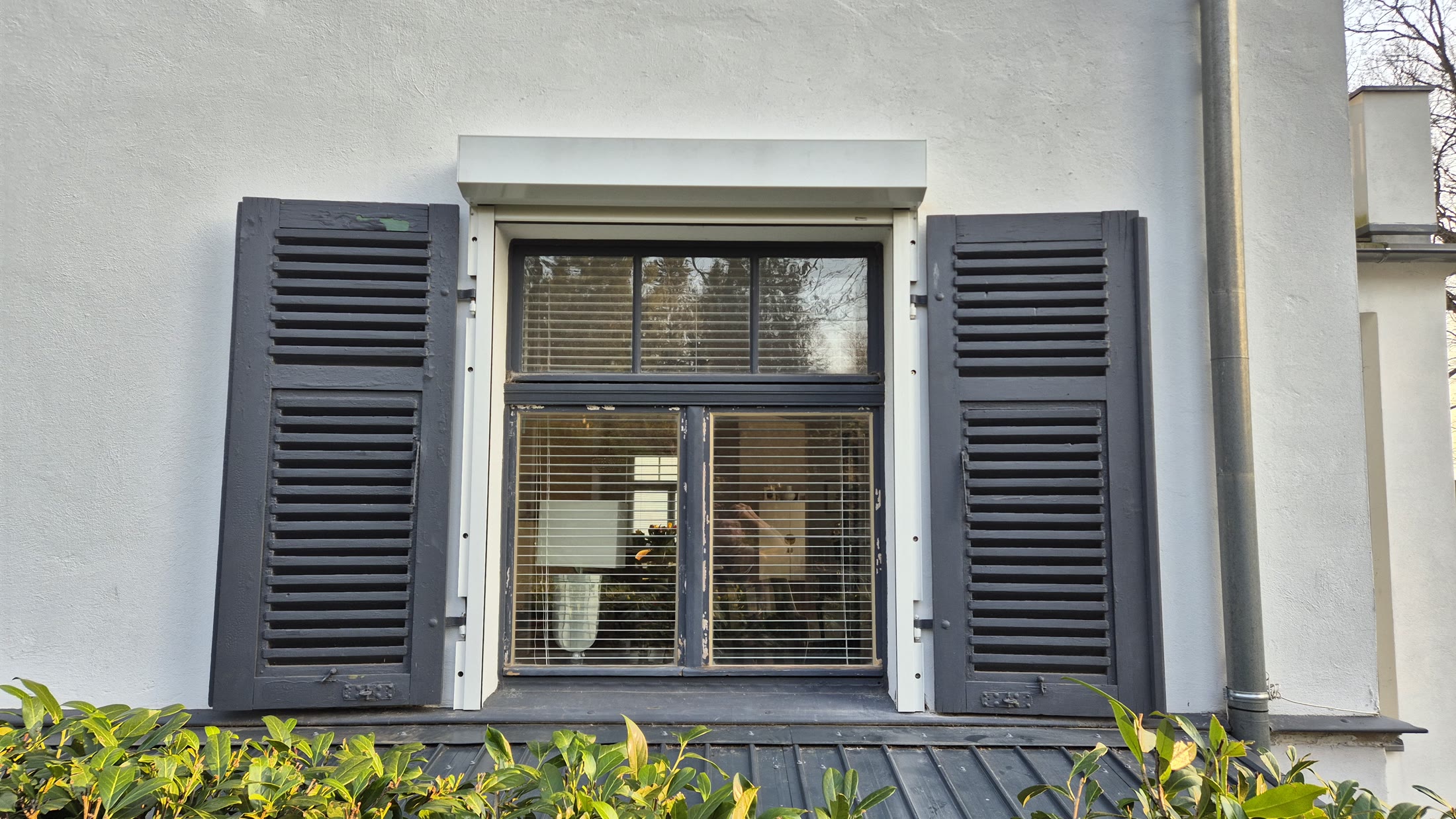 Hausfassade mit Fenster und angrenzender Terrasse
