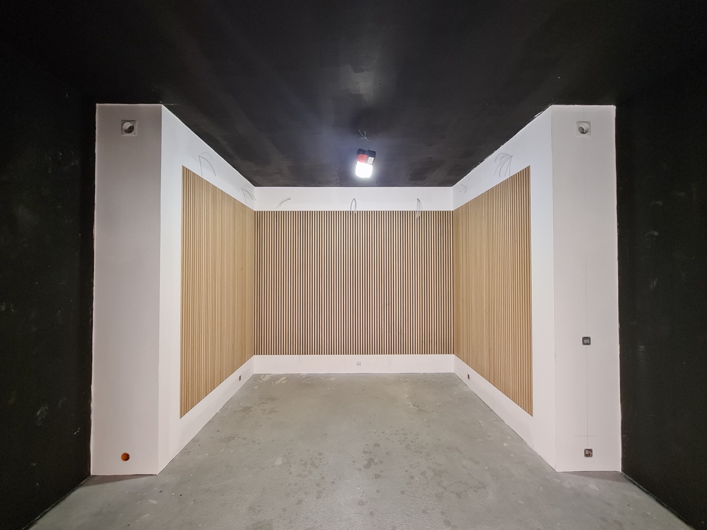 Raum mit neu gebauter Holzlamellenwand und dunkel abgesetzter Decke – Zimmermannsarbeit von Deutscher – Haus. Bau. Montage.