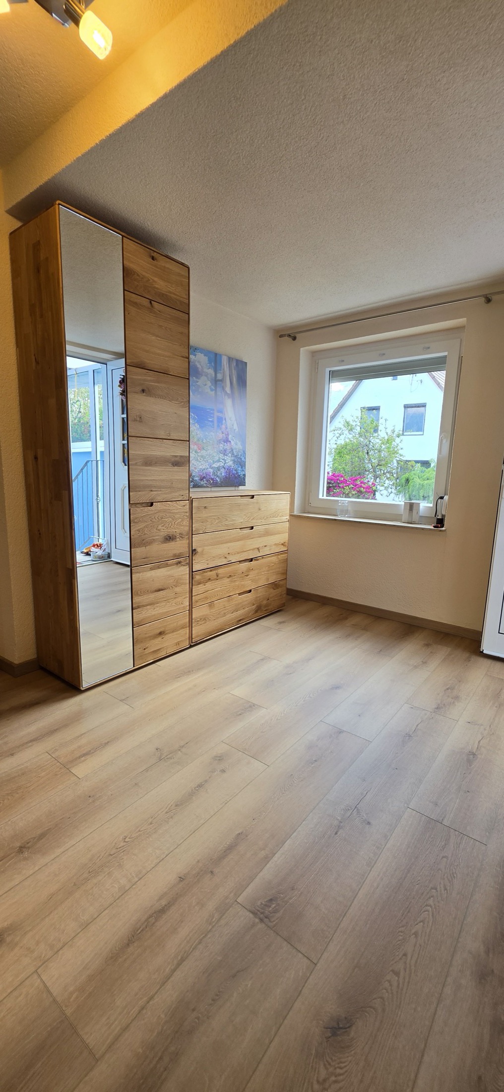 Renovierter Wohnraum mit montierten Möbeln und neu verlegtem Boden