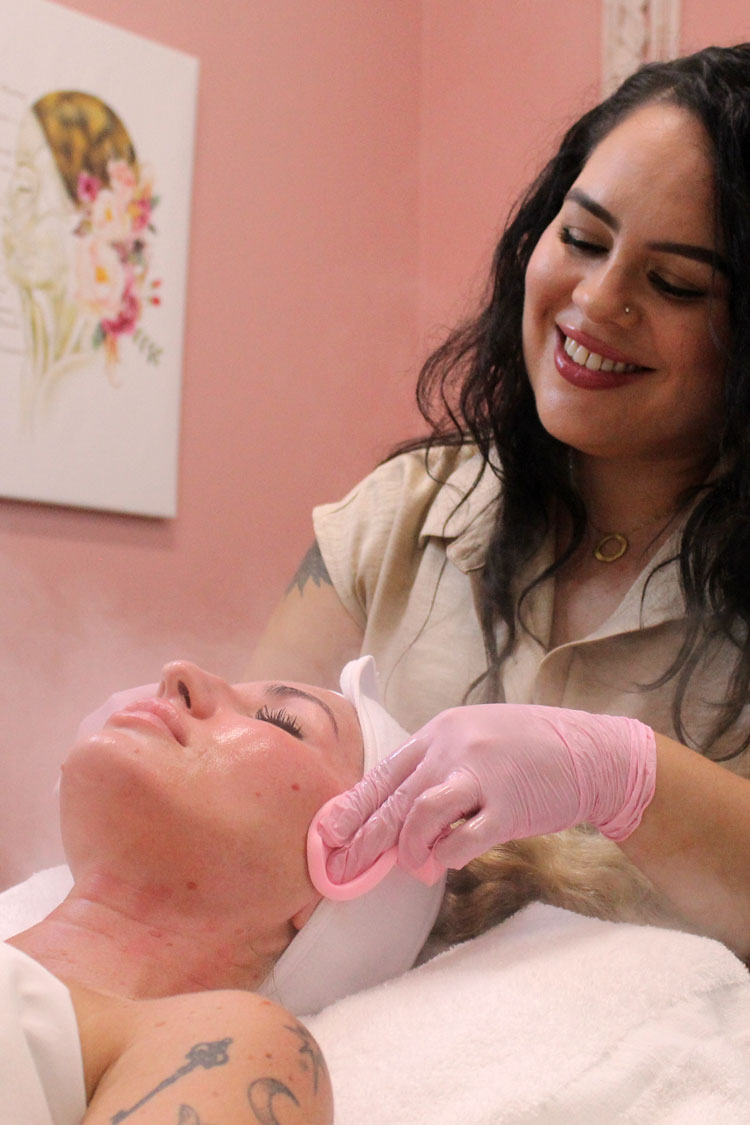 Sarah performing a customized facial treatment on a client