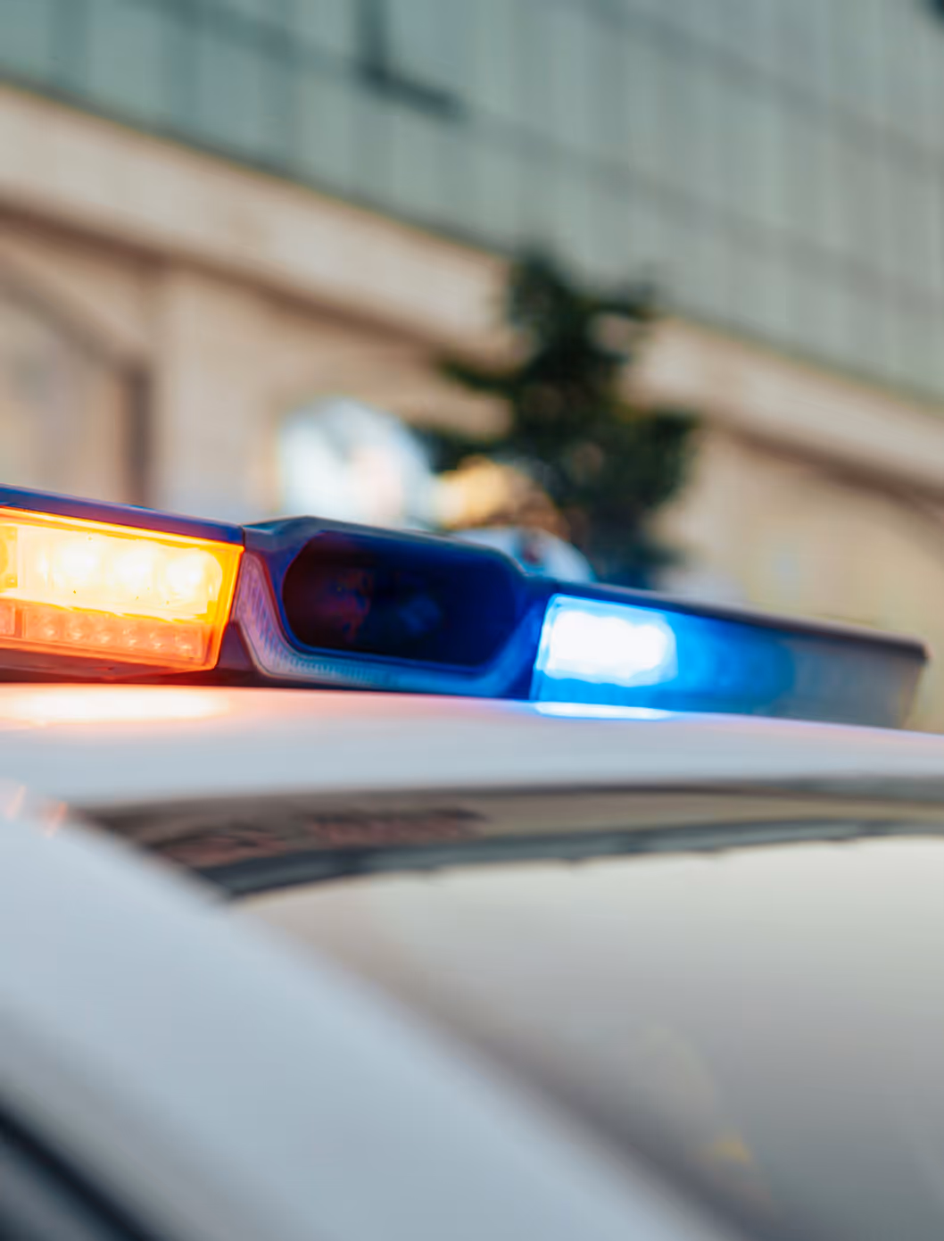 Close-up of a police car's light bar with blue and yellow flashing lights.