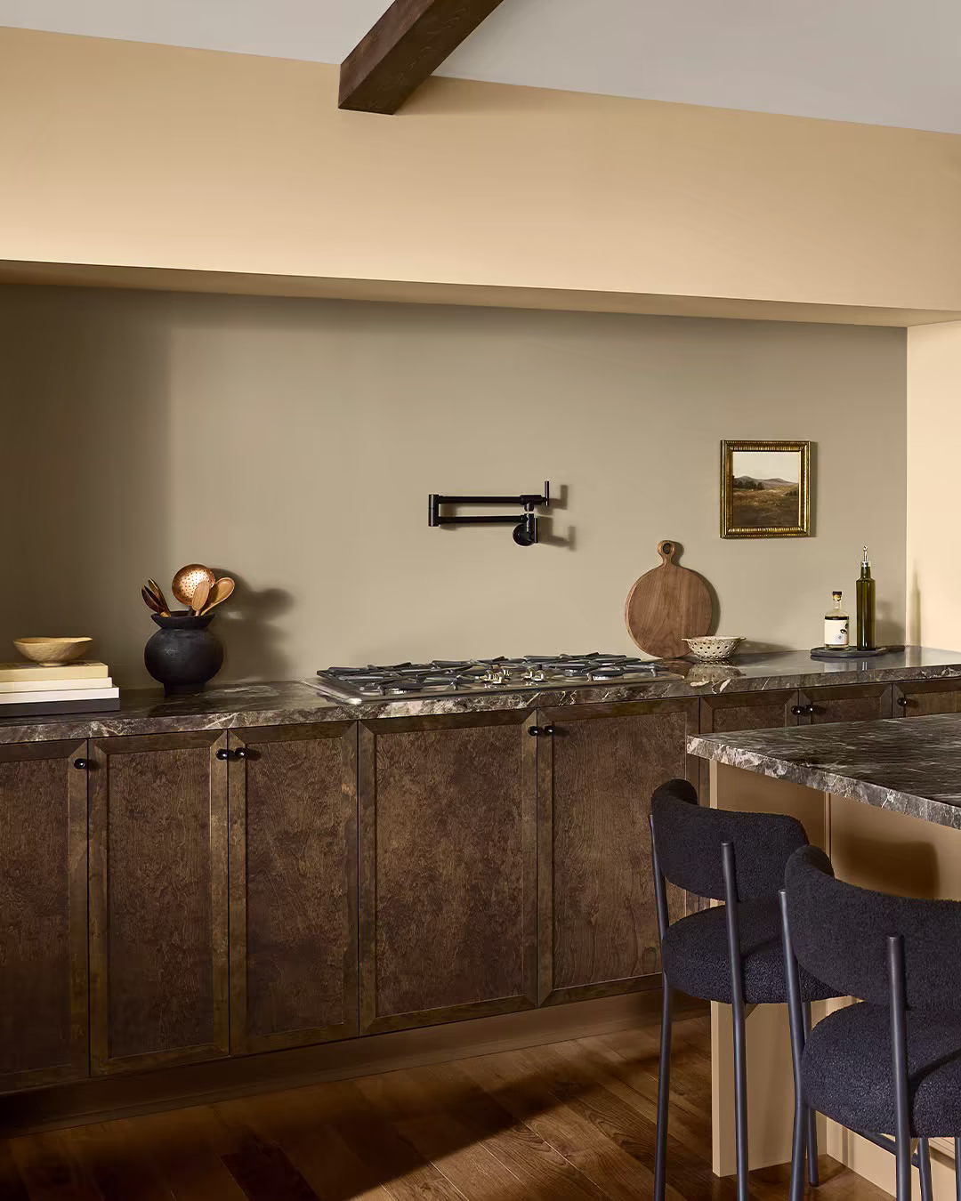 Kitchen with a sage-green painted backsplash wall, dark wood cabinetry, and marble countertops.