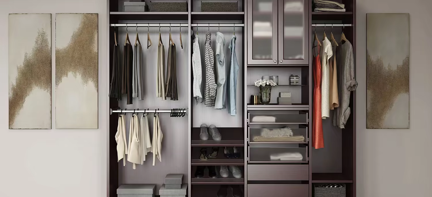 Custom walk-in closet system with hanging rods, shoe shelving, drawers, and glass-front cabinets.