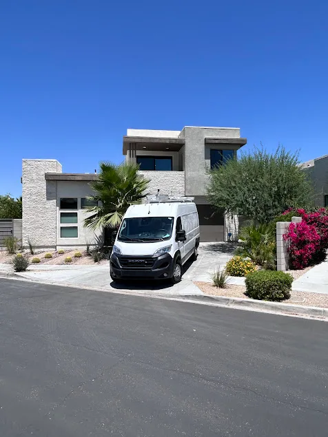 "Professional trade service vehicle parked outside a modern custom estate in Palm Springs, offering 24/7 emergency water heater repair and water quality diagnostics.