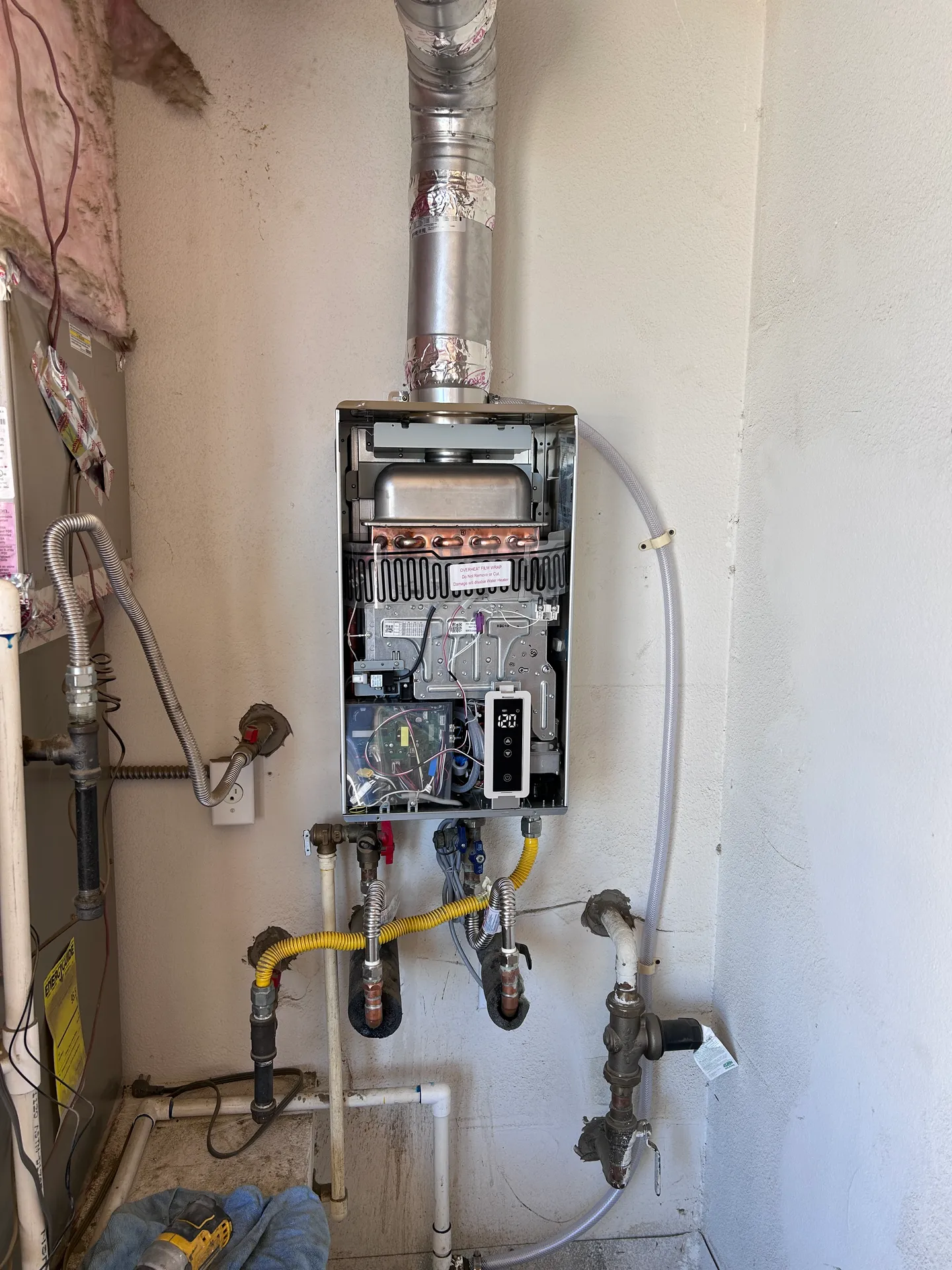 "Elite tankless water heater installation in progress, showcasing precision internal engineering, manifold layout, and master-level utility connections.