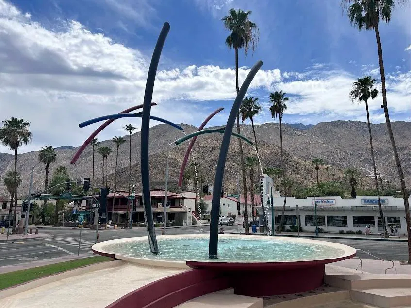 The mid-century style public fountain welcoming visitors to downtown Palm Springs, California, framed by the San Jacinto mountains.