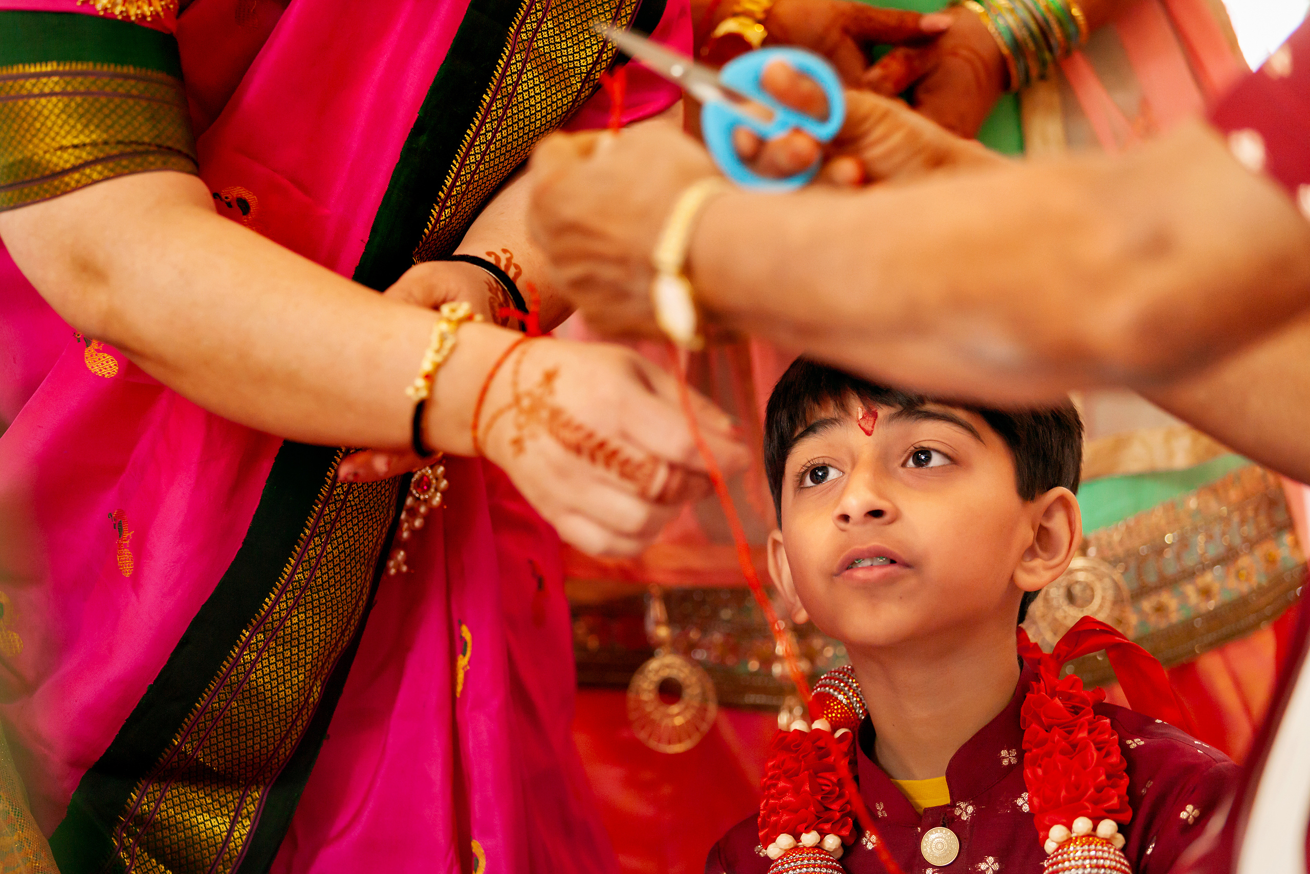 Young boy watches as his mother and grandmother prepare ceremonial thread during his Upanayana (sacred thread) ceremony