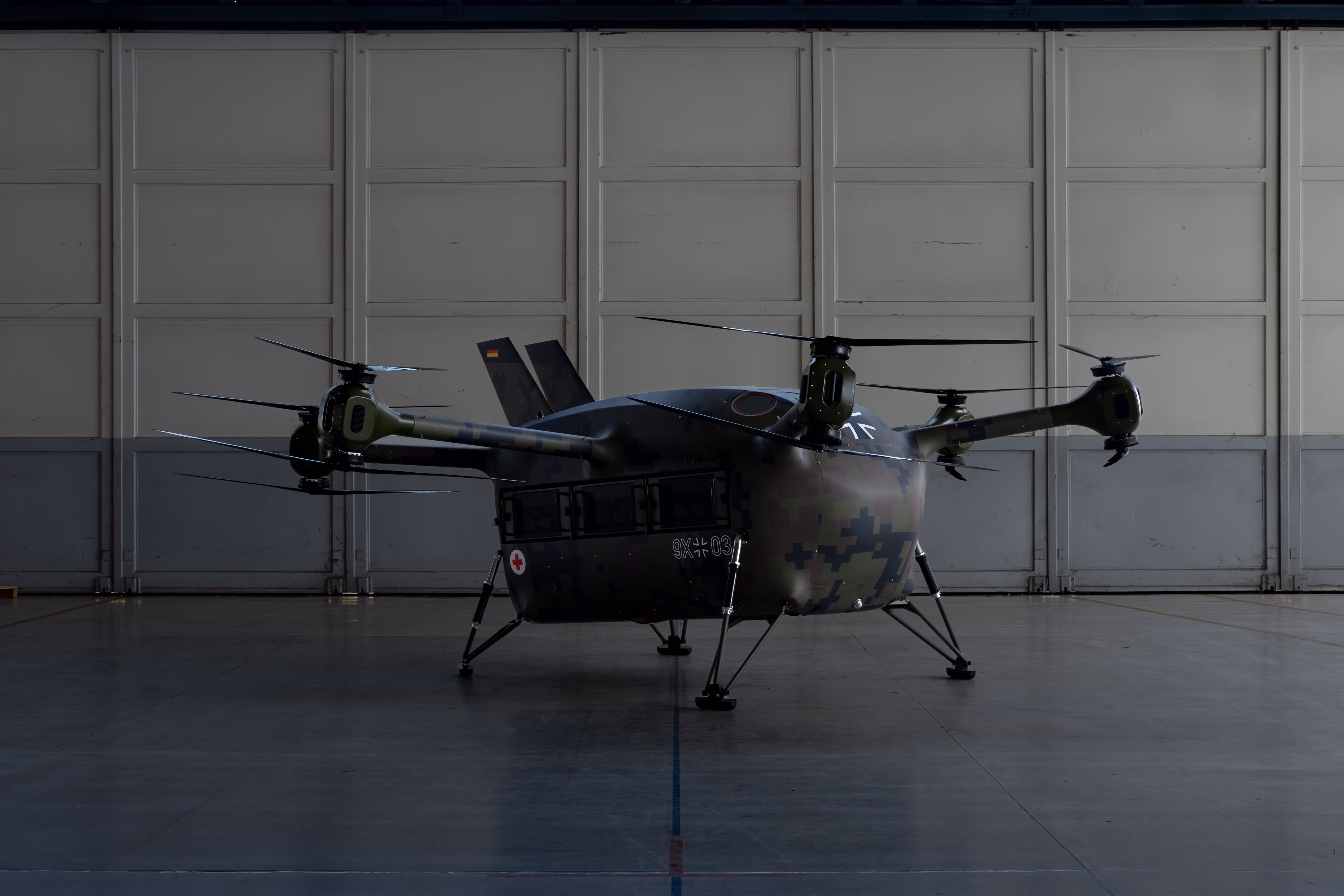 Side view of the Grille rescue drone parked in a hangar with rotor booms extended.