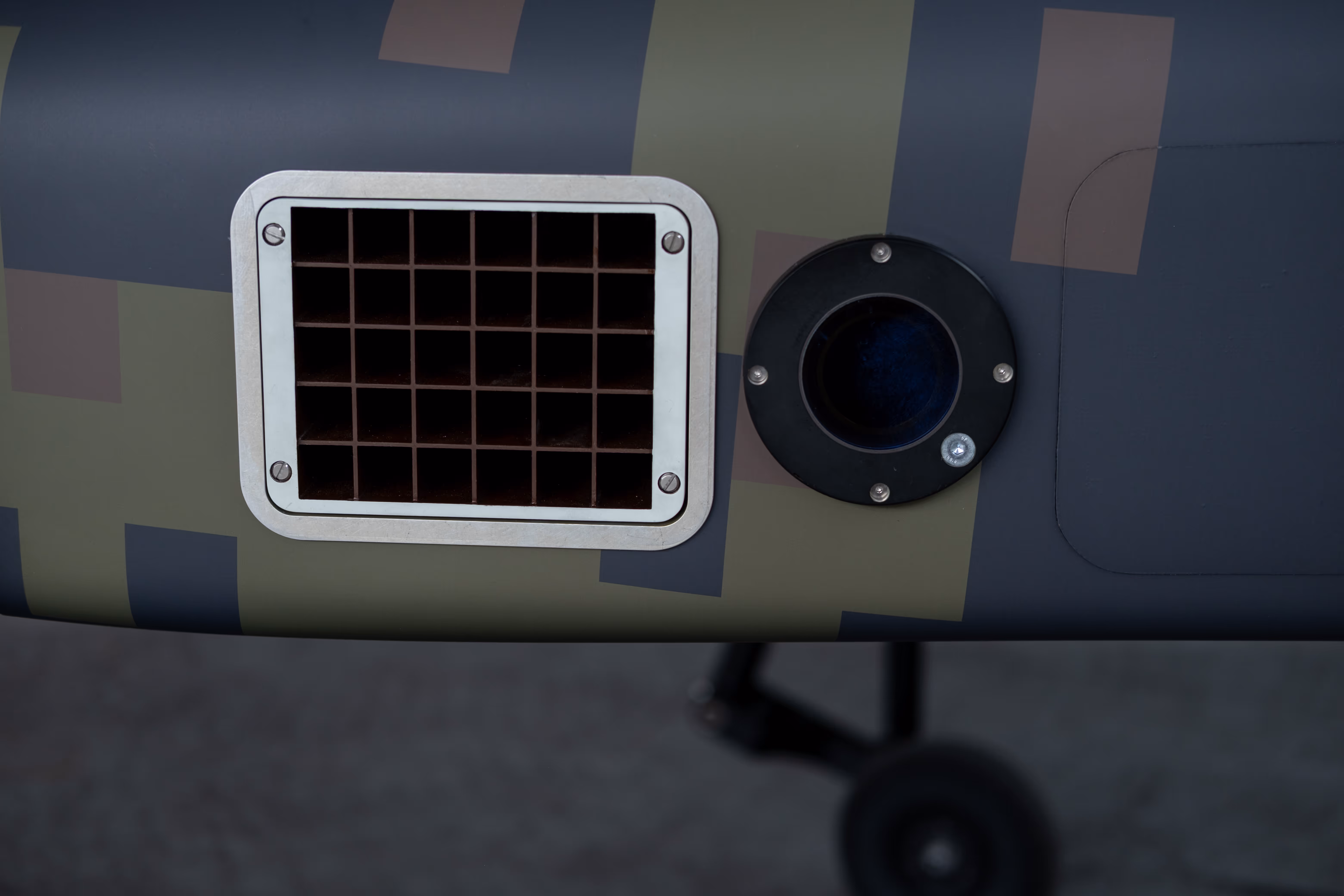 Cooling vent grille and sensor port on the Wespe drone's camouflaged fuselage.