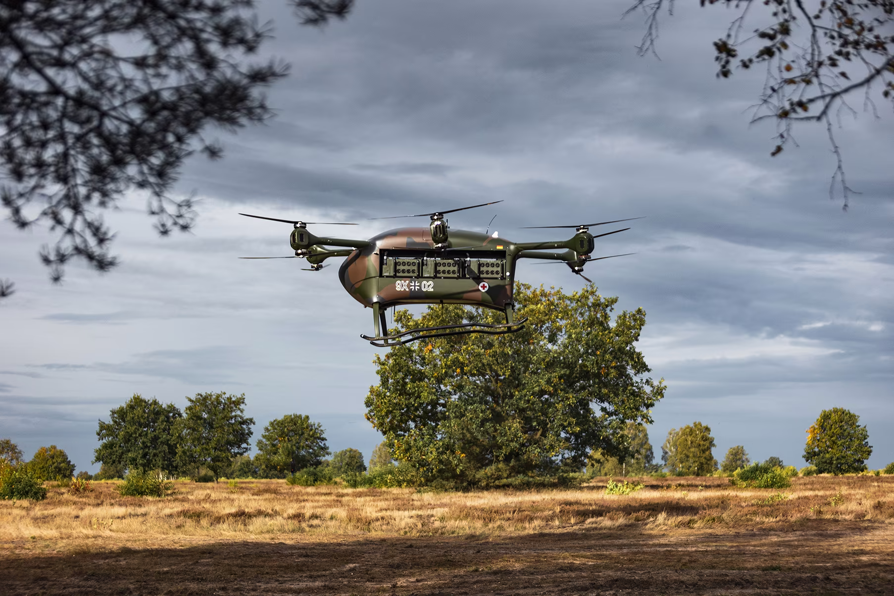 Grille drone flying low over a heath under storm clouds