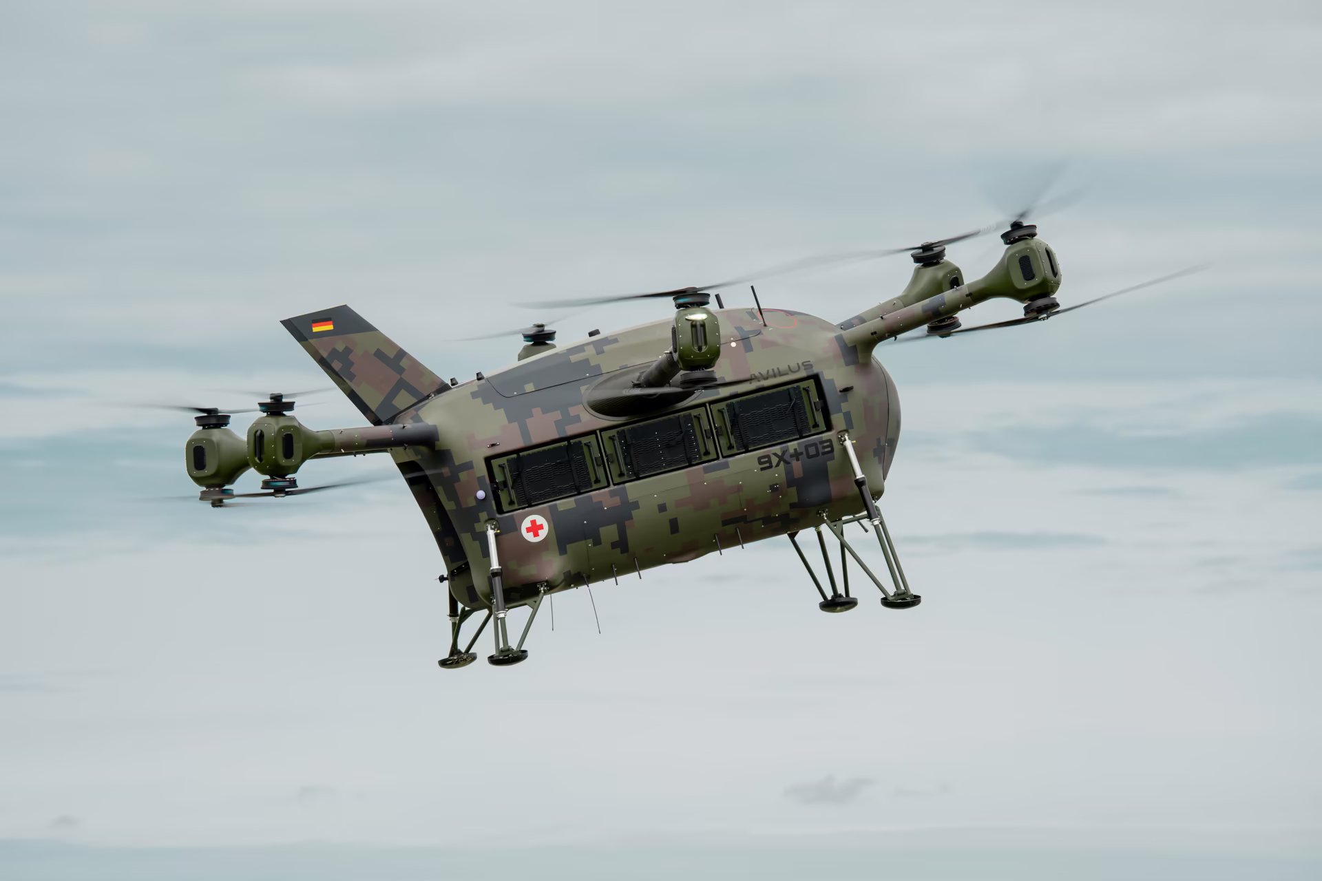 Grille medevac drone in Bundeswehr camouflage hovering over a field