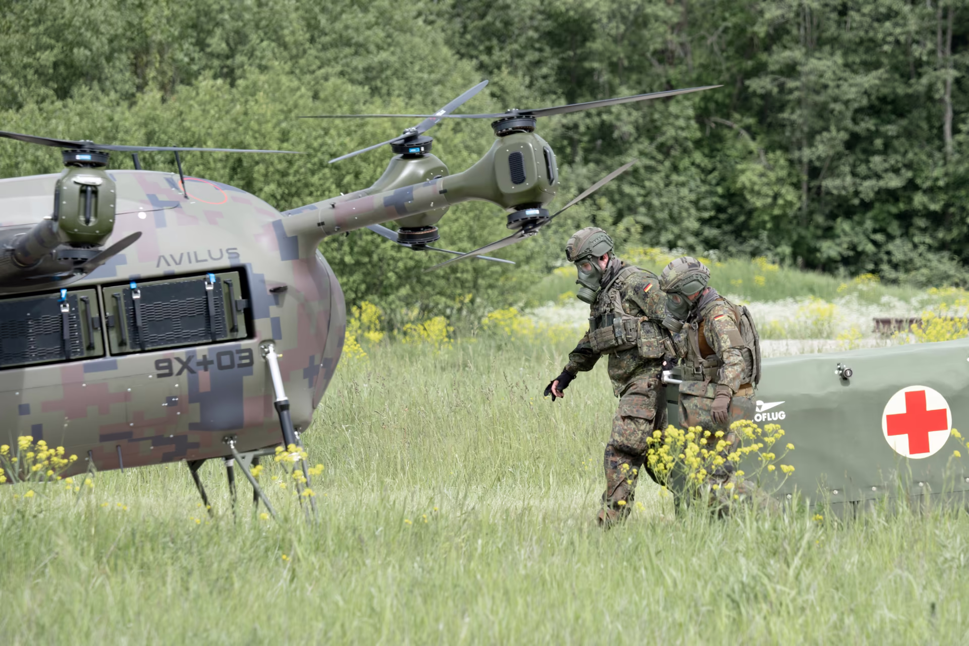 Two soldiers carrying a stretcher to the Grille 9X-03 medevac drone