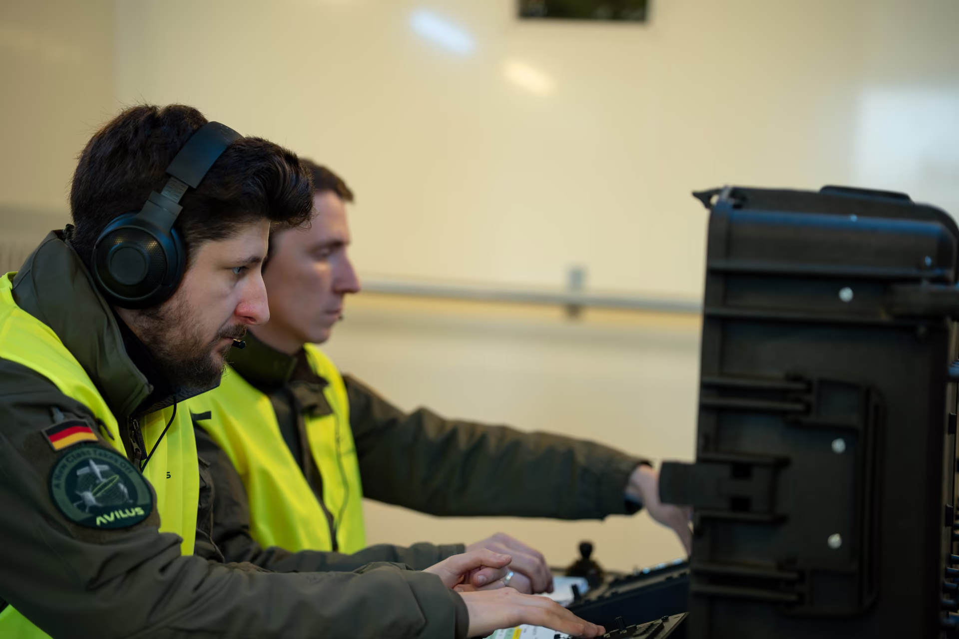 Two operators at a ground control station wearing headsets