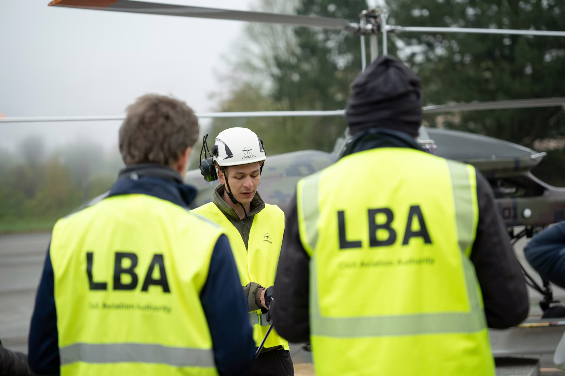 LBA inspectors in yellow vests talking on the apron beside a drone