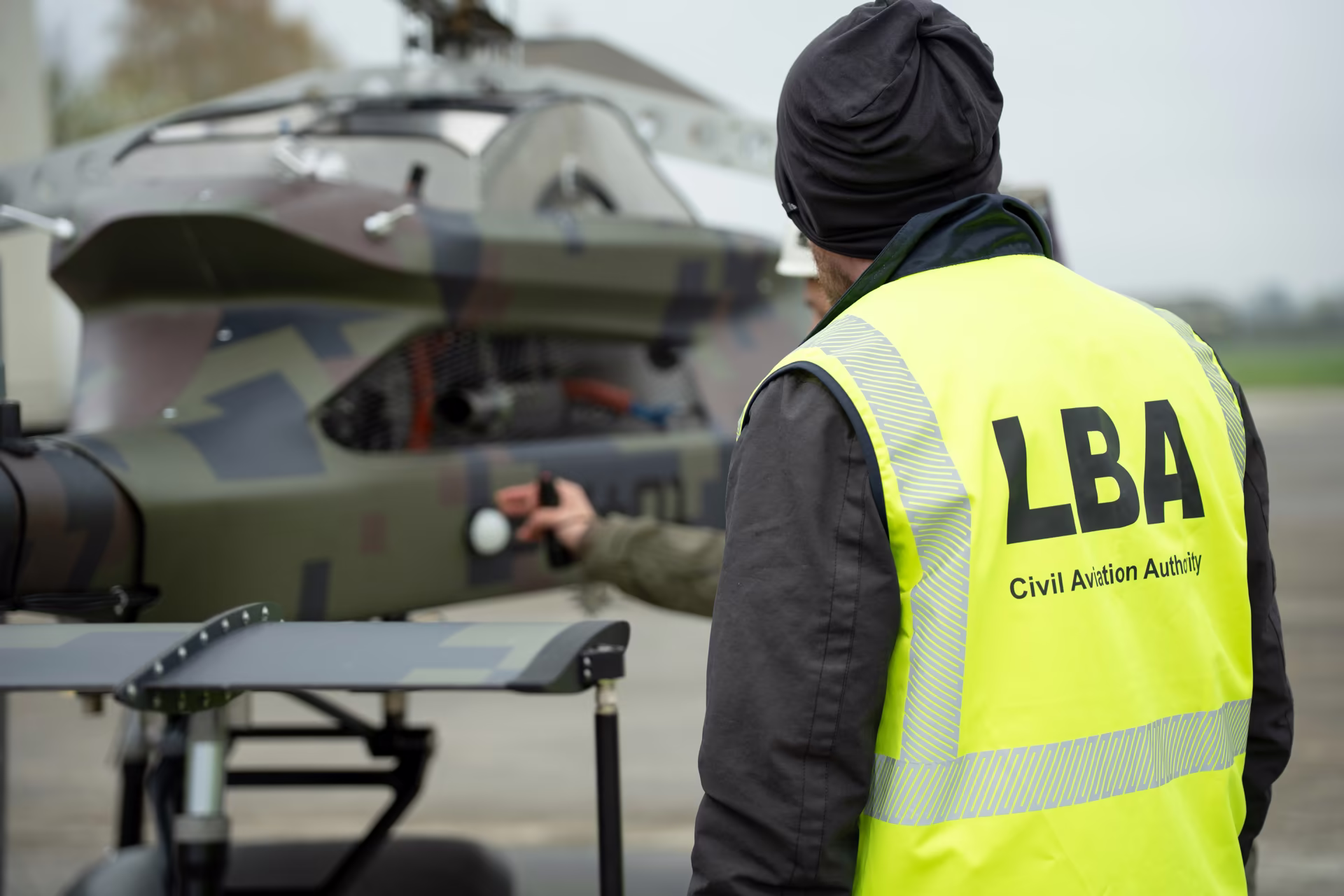 LBA inspector examining the camouflaged Grille drone on the apron