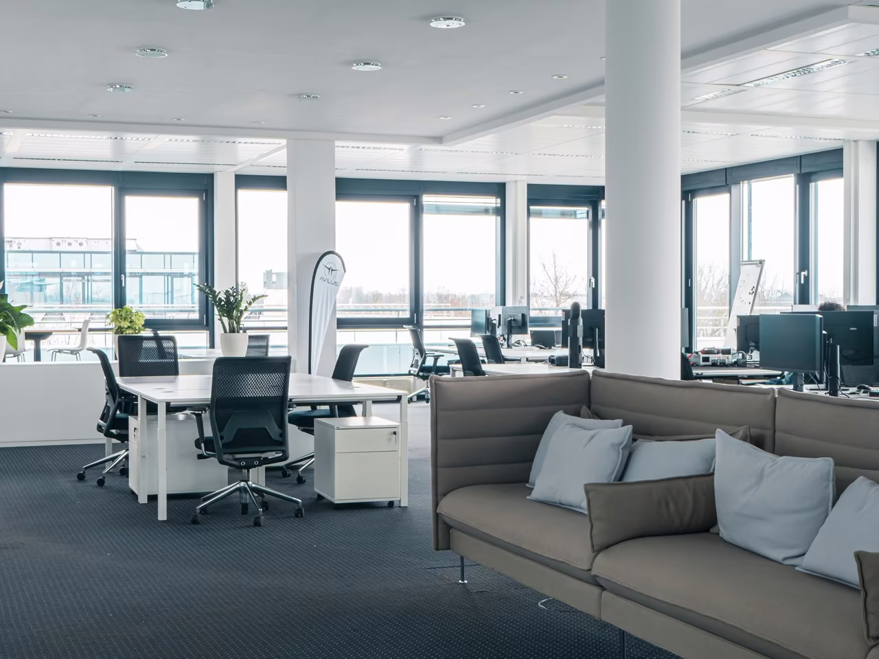 Meeting area with sofa and desks at the Ismaning office