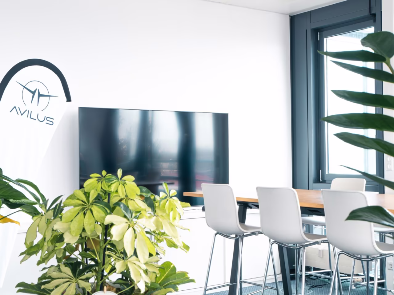 Avilus logo wall and lounge seating at the Ismaning office