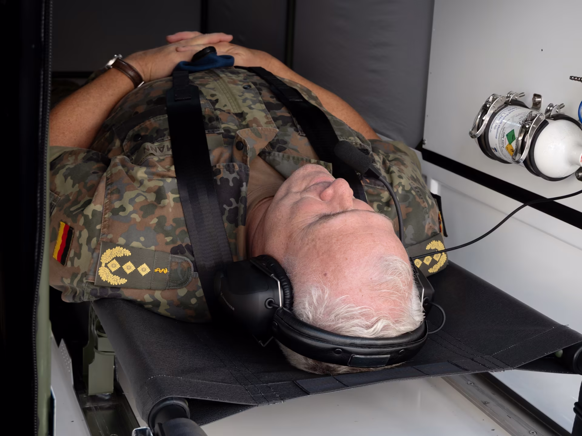 General Ralf Hoffmann lying strapped into the Grille medical cabin wearing a headset