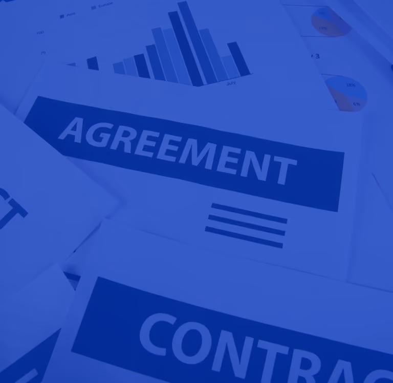 Printed papers labeled Agreement and Contract with bar and pie charts in the background.