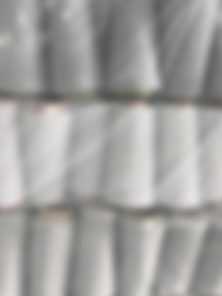 Rolls of white fabric prepared for garment production.