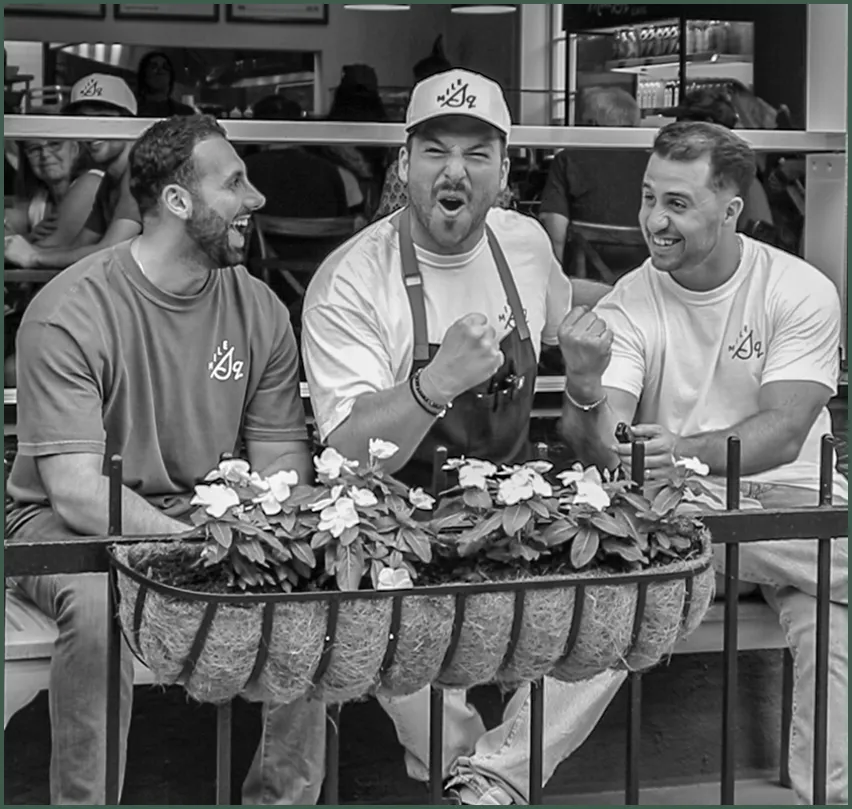 A black and white photo of three men laughing.