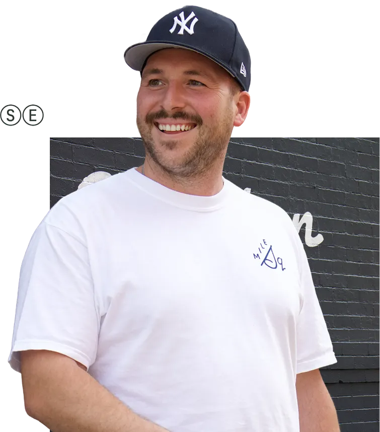 A man wearing a yankees hat and white shirt.
