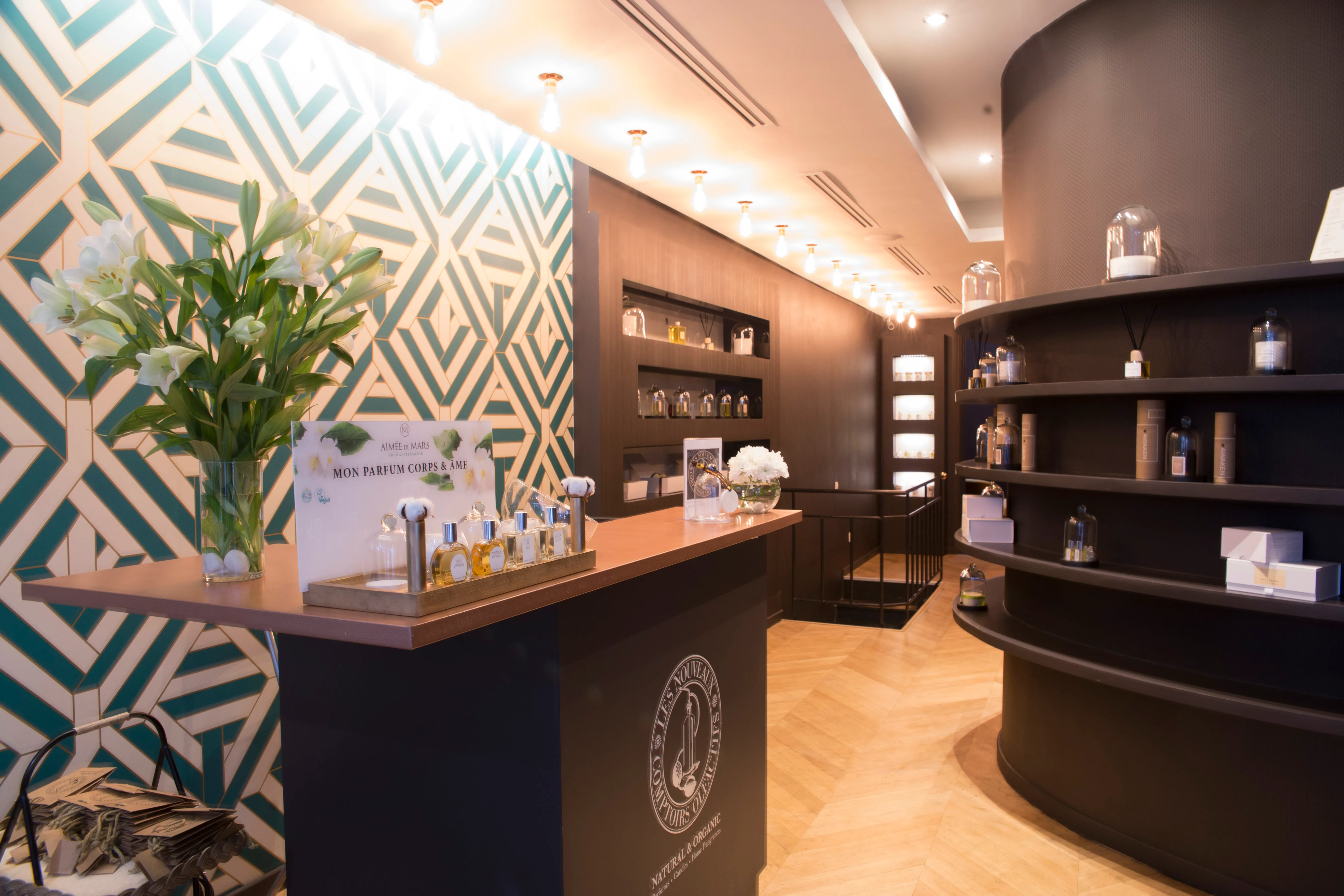 Intérieur de la boutique moderne avec comptoir, étagères sombres et fleurs blanches sur le comptoir.