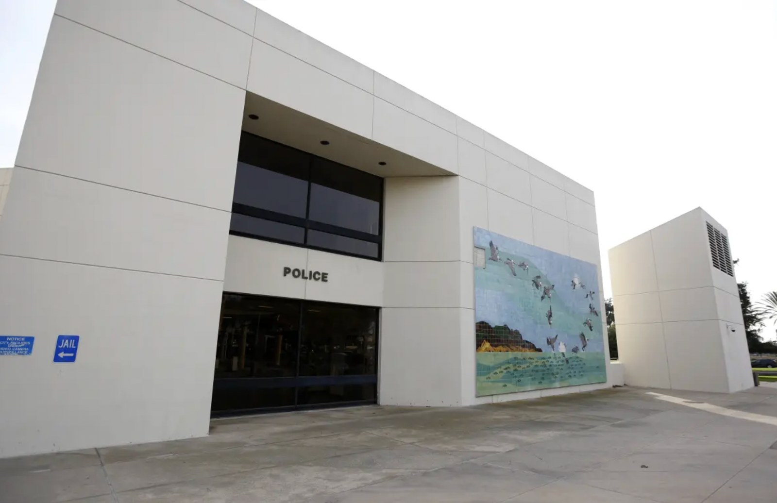 Huntington Beach Police Department exterior with police entrance and jail direction sign