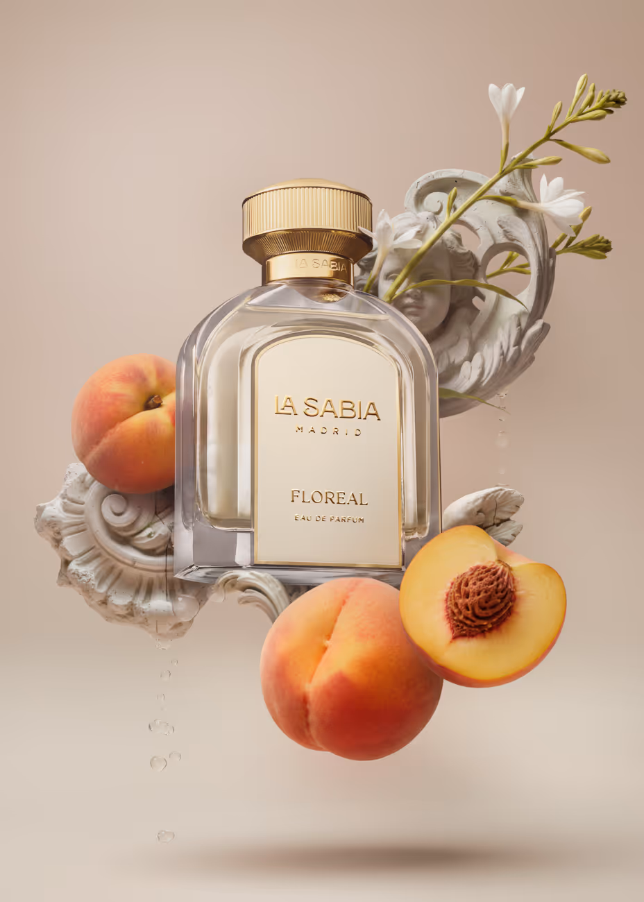Perfume bottle labeled La Sabia Madrid Floreal with peaches and white flowers on ornate background.
