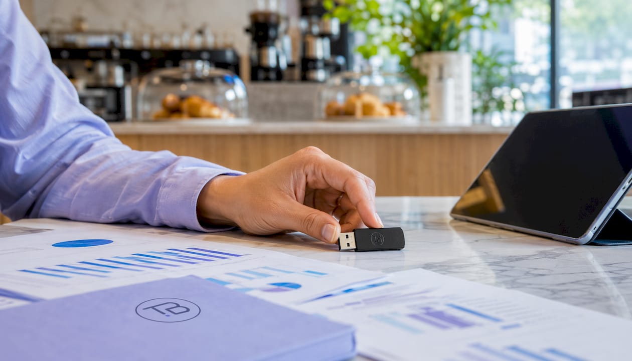 Overhead close-up of hand with USB drive and marketing tools