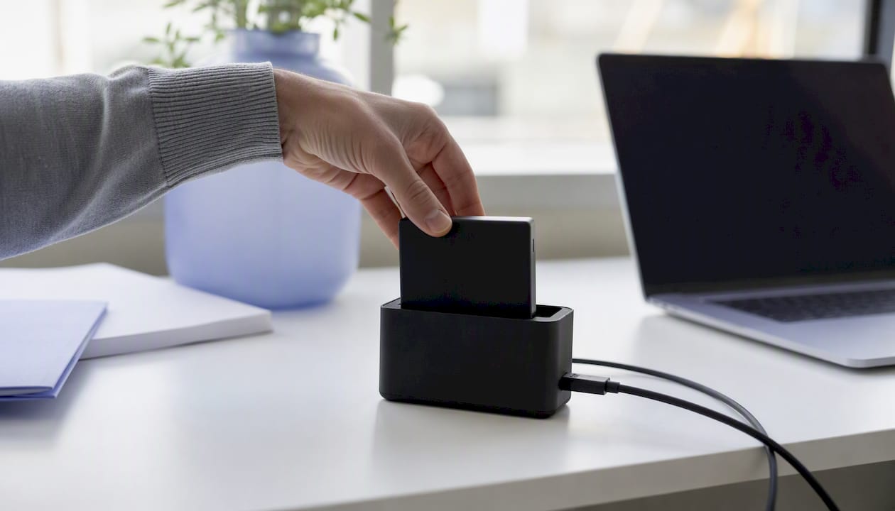 Hands connecting external hard drive for backup