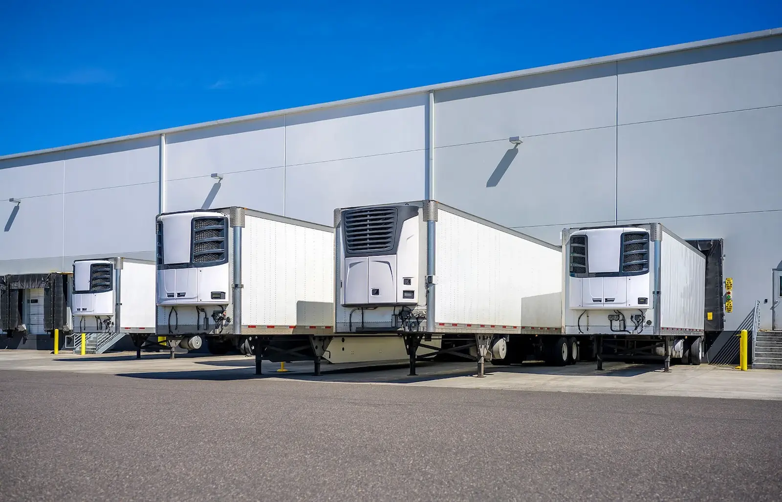 Refrigerated trailers backed into loading dock bays at a food distribution warehouse