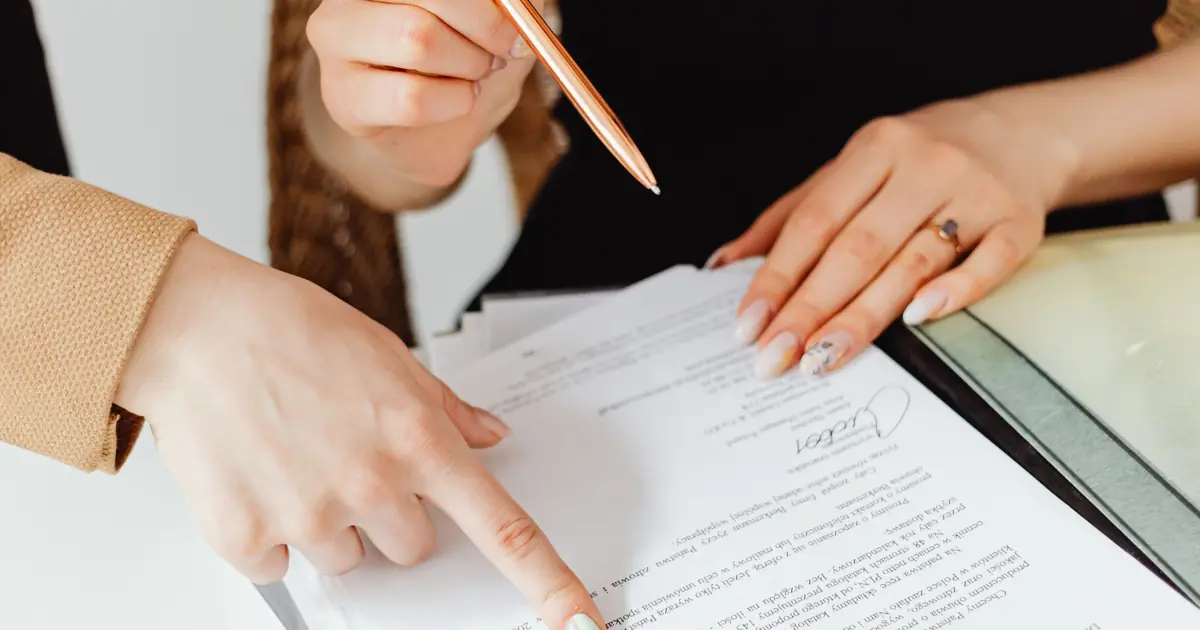 Two people reviewing a freight rate agreement at a desk, one pointing to a line item while the other holds a pen.