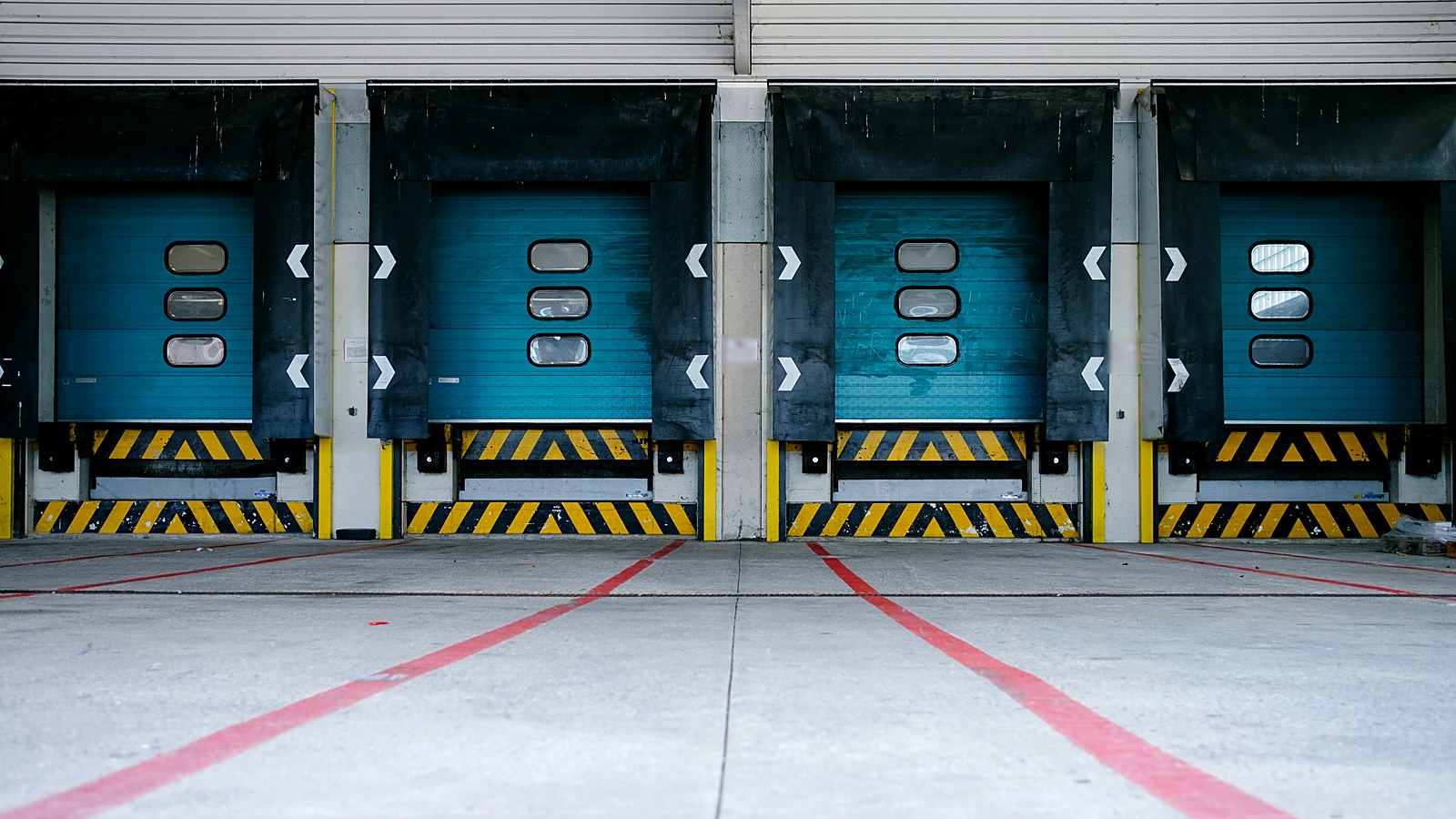 Row of loading dock doors at a distribution center with empty approach lanes