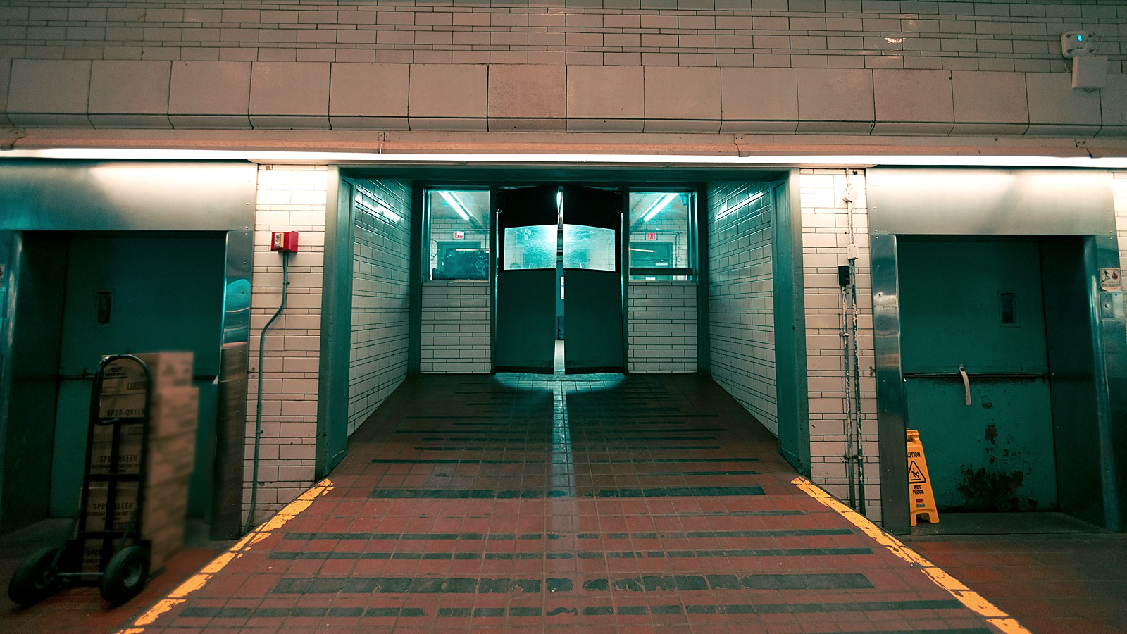 Refrigerated receiving corridor with staged cases at a food distribution facility